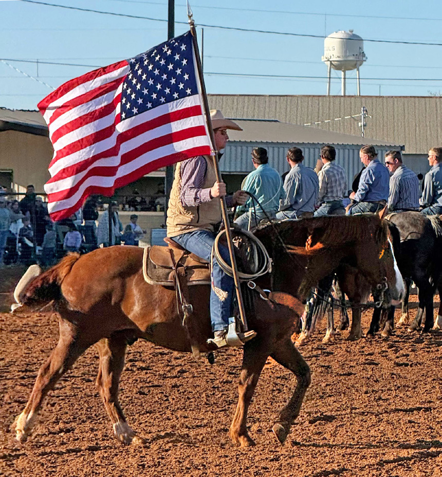 Chace Thompson carries the U.S. flag into the arena to get the rodeo started while the National Anthem plays. | JONATHAN BIRKENFELD PHOTO