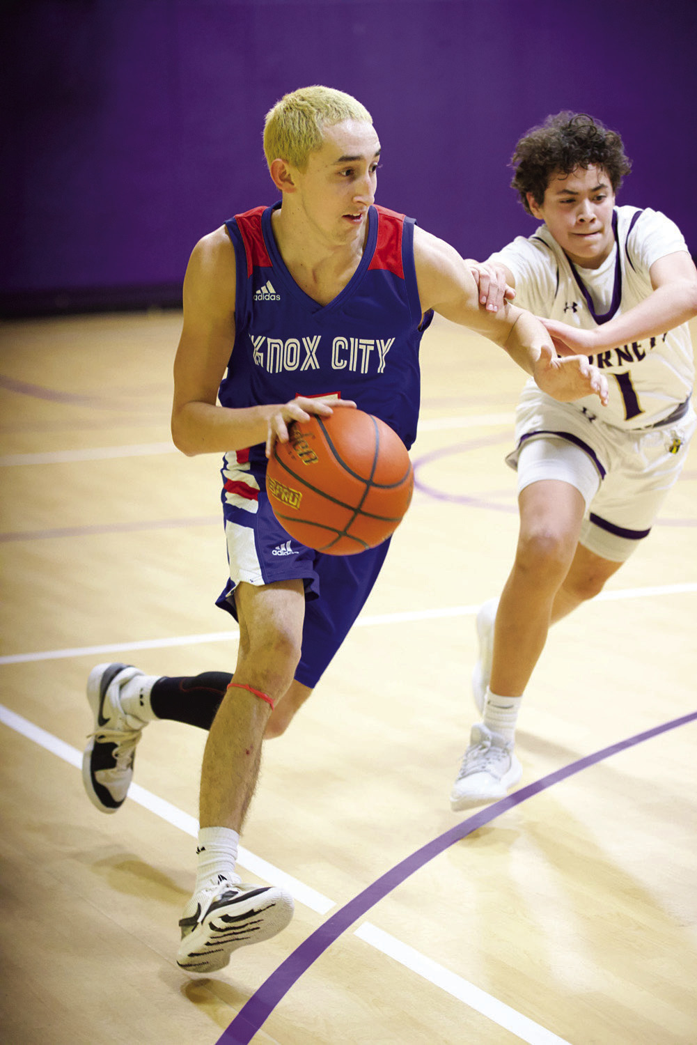 Jerry Grayson pushes his way down the court despite the defensive pressure. | SHERI BATY PHOTO