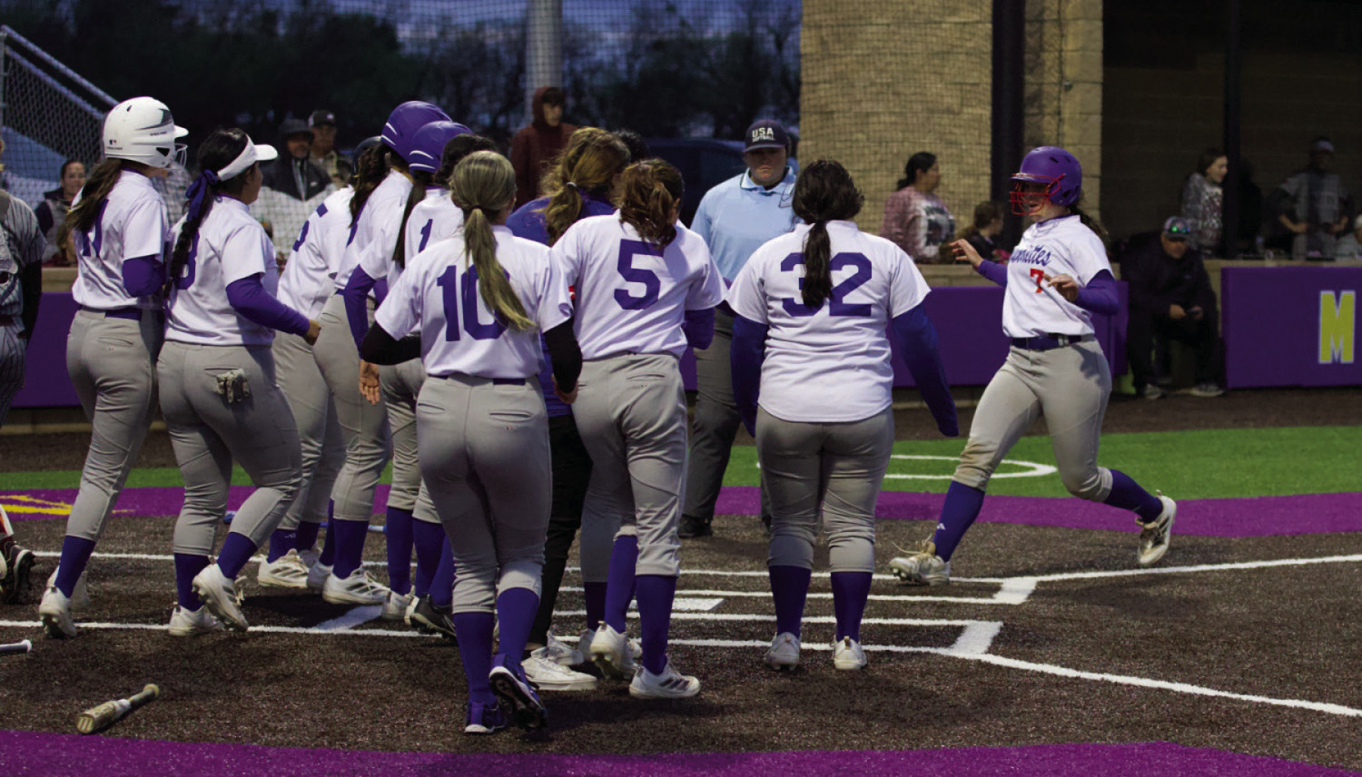 Savannah Friddle is greeted by her teammates at homeplate for her over the fence centerfield homerun. | SHERI BATY PHOTO