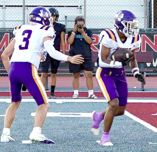 WILSON GETS THE HANDOFF Haiden Bowman hands the ball off to Kiyryn Wilson.