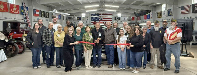NEW MUSEUM FOR OLD VEHICLES Sam Baker cut the ribbon at the grand opening of the new location of Fort Sam Military and Antique Vehicle Museum of Haskell County, surrounded by the museum’s board of directors, spouses, family members, staff, Haskell Chamber of Commerce members, volunteers and members of the VFW Post 9179 of Stamford. | COURTESY PHOTO