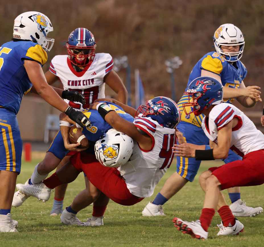 HOUNDS VERSUS DAWGS Knox City’s Joel Contreras swallows up the Spur Bulldog runner in the Hounds’ 56-0 win over Spur, which ended at halftime. FULL STORY, PAGE 5 | SHERI BATY PHOTO
