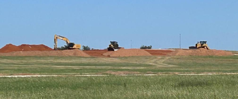 PLAYING IN THE DIRT In this long-distance view, bulldozers and excavator resemble Tonka trucks sitting in a pile of dirt just waiting for a kid to come and move some dirt. The real-life machines are part of the construction equipment on the ZSS solar project.