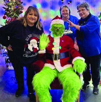 IMPERSONATING SANTAThe Grinch came to town impersonating Santa and stopped for a photo opportunity with Donna Hyatt, Lina Trevino and Celena Callicotte. | COURTESY PHOTO