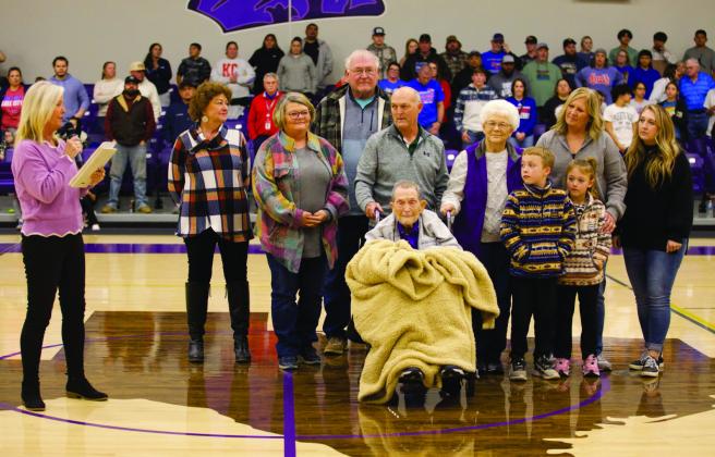 MOGUL MEMORIES Wearing Munday purple Tuesday night, teacher and coach Dan Sloan hears the pronouncement that Munday High School’s old gymnasium will be named the “Coach Dan Sloan Gym.”Elementary principal Kristi Bufkin read the proclamation during the break between the varsity girls’game and the varsity boys’game. The Munday Moguls played Knox City Greyghounds. | SHERI BATY PHOTO