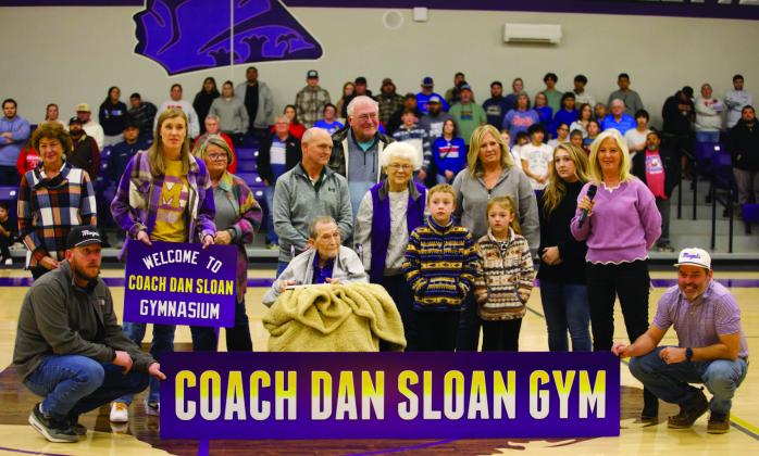 MUNDAY HONORS Munday Elementary principal Kristi Bufkin congratulates Dan Sloan Tuesday night after reading a proclamation that the old Munday School gymnasium will be named in his honor. Sloan coached and taught Munday students for decades. The gym naming ceremony took place at center court between the varsity girls’and boys’games at the new gym.The Munday Moguls played the Knox City Greyhounds. | SHERI BATY PHOTO