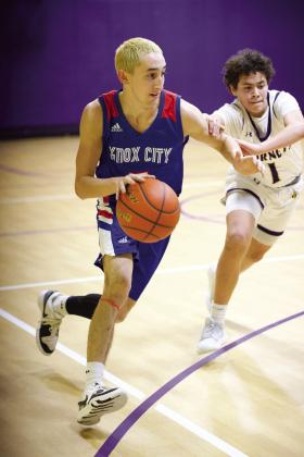 Jerry Grayson pushes his way down the court despite the defensive pressure. | SHERI BATY PHOTO