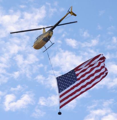 9/11 FLYOVER Dustin Johnson of Cedar Ridge Aviation flies the flag over Knox City School Friday, Sept. 11, in commemoration of the 25th anniversary of terrorist attacks on American soil. | SHERI BATY PHOTO