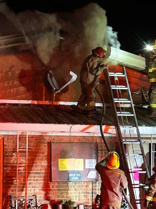 NOWAY IN In the early going Saturday night, Knox City firefighters searched for a way into the attic of the 1968 Knox City Country Club buidling, fighting thick smoke that obscured the flames raging inside the attic. | NEWS-COURIER