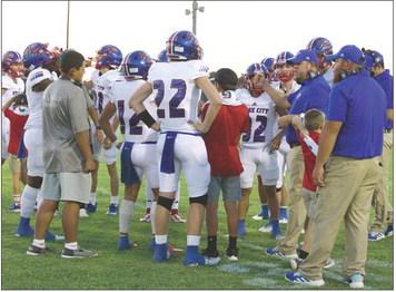 The Greyhounds with Coach Callaway in a sideline motivational meeting. | SHERI BATY PHOTO