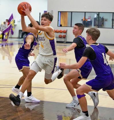 THROUGH THE LANE Carson Willison drives through the lane surrounded by Hornets. | LACI BOWMAN PHOTO