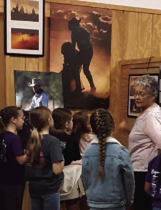 Mary Jane Young shows an exhibit to the students.
