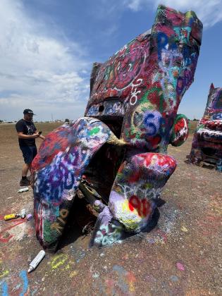 CARS OR CARCASSES? At the Cadillac Ranch today, decades of accretions of spray paint seem to have melted the Caddies’ forms acrylic flowstone, rendering them hardly recognizable as automobiles.
