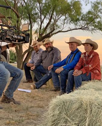 CIRCLE BAR RANCH owner-operators Jerry Bob Daniel and his wife, Eugenie Daniel, talk last Thursday night to the camera and a sizable audience gathered at Truscott, one stop on the cross-country route of a wagon train bound for the Santa Rosa Roundup. Others, from left, are Kyle Everson and Colton Daniel. The professional recording of the evening could end up, at least in part, in a museum the Daniels plan to build in downtownTruscott. | PHOTO BY HANABA MUNN WELCH
