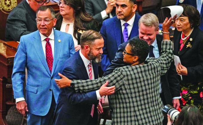 ACROSS THE AISLE State Rep. Toni Rose (D-Dallas) hugs fellow Reps. Dustin Burrows (R-Lubbock) and David Cook (R-Mansfield) after Burrows won the vote for speaker Jan. 14. | ELI HARTMAN/THE TEXAS TRIBUNE