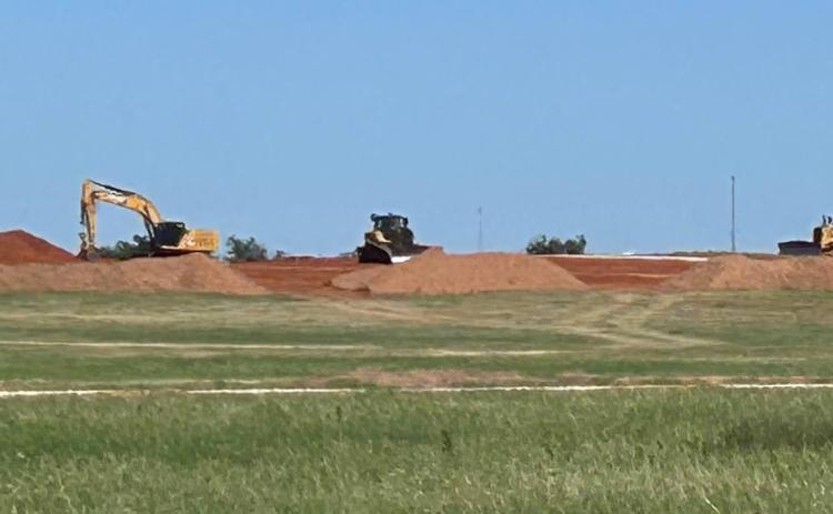 PLAYING IN THE DIRT In this long-distance view, bulldozers and excavator resemble Tonka trucks sitting in a pile of dirt just waiting for a kid to come and move some dirt. The real-life machines are part of the construction equipment on the ZSS solar project.