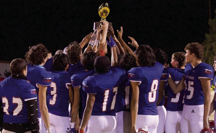 CHAMPS The Greyhounds raise the Bi-District championship trophy. | SHERI BATY PHOTO