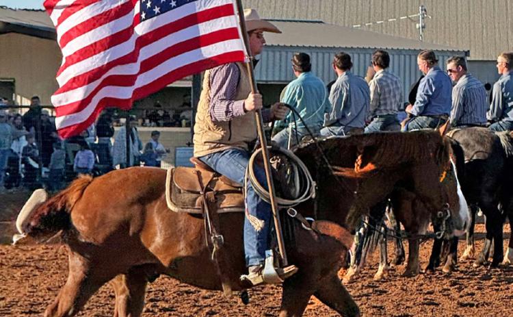 Chace Thompson carries the U.S. flag into the arena to get the rodeo started while the National Anthem plays. | JONATHAN BIRKENFELD PHOTO