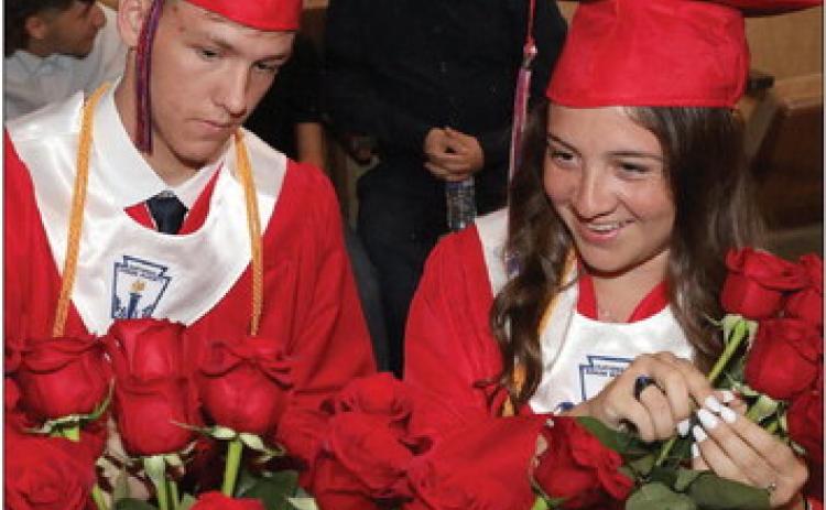 Gage Morrow and Callie Grimsley pick their roses to share with their loved ones at the KCHS graduation ceremony Sheri Baty/The Knox County News-Courier