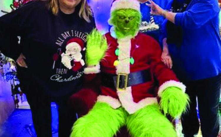 IMPERSONATING SANTAThe Grinch came to town impersonating Santa and stopped for a photo opportunity with Donna Hyatt, Lina Trevino and Celena Callicotte. | COURTESY PHOTO