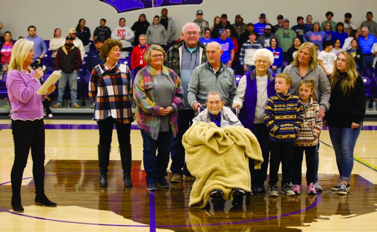MOGUL MEMORIES Wearing Munday purple Tuesday night, teacher and coach Dan Sloan hears the pronouncement that Munday High School’s old gymnasium will be named the “Coach Dan Sloan Gym.”Elementary principal Kristi Bufkin read the proclamation during the break between the varsity girls’game and the varsity boys’game. The Munday Moguls played Knox City Greyghounds. | SHERI BATY PHOTO
