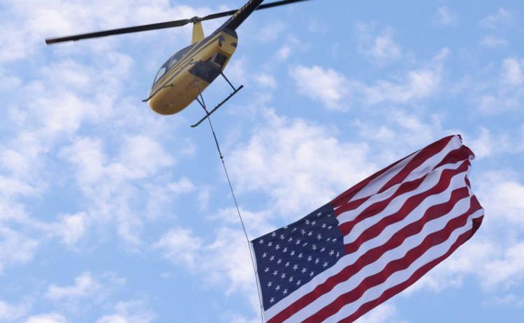 9/11 FLYOVER Dustin Johnson of Cedar Ridge Aviation flies the flag over Knox City School Friday, Sept. 11, in commemoration of the 25th anniversary of terrorist attacks on American soil. | SHERI BATY PHOTO