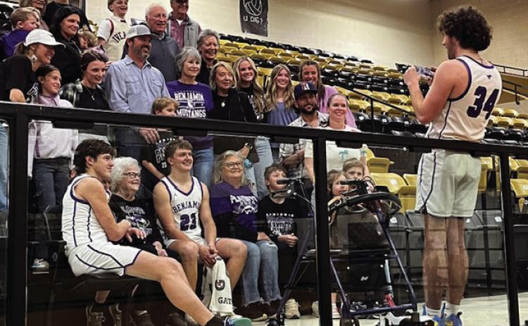 SEASON MEMORIES SeniorTallon Hayes helping out after his last game, photographing senior Hudson Cates and sophomore Everett Cates with the Cates family fan base. | SUE JANE SULLIVAN