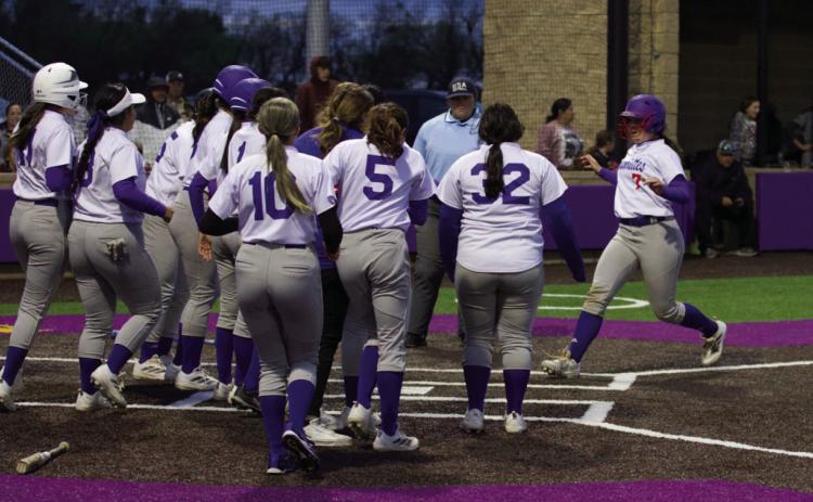 Savannah Friddle is greeted by her teammates at homeplate for her over the fence centerfield homerun. | SHERI BATY PHOTO